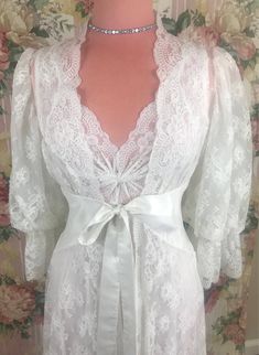 This is an Olga Designer Gold Label Peignoir set in a Bridal White color in size Small.  This is one of the most beautiful Peignoir robes I have ever come across!  It is in excellent condition!  I would even say that this robe was never worn before just by the look and feel of it.  This beautiful nightgown has a lovely lace bodice and a extra large sweep skirt.  There are two small flaws on the gown.  One is a run and the other is a pic (refer to pictures).  Aside from that the nightgown and tag feel brand new. This is my most rare set.  This is a very hard to find robe and nightgown.  The detail  on this robe is incredibly intricate with puff chiffon sleeves and scalloped lace edges to make this a very elegant look.  Please feel free to ask me any questions regarding size/fit as I do not Ethereal Fits, Vintage Nightwear, Dreamy Outfits, Bridal Robes Personalized, Beautiful Nightgown, Vintage Night, Bride Lingerie, Night Gowns, Peignoir Sets