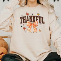 Celebrate the season of gratitude in style with our Thankful Coquette Shirt! This charming and festive shirt combines elegance with cozy comfort, making it the perfect choice for Thanksgiving gatherings and fall festivities. Whether you're enjoying a family dinner or a casual day out, this shirt will keep you looking stylish and feeling thankful. With a retro-inspired design, this Thanksgiving top adds a nostalgic touch to your autumn wardrobe. Available in both t-shirt and sweatshirt options, it's perfect for layering up as the weather cools. Embrace the cozy vibes and make this festive fall shirt your go-to for the season! Before ordering, check the dimensions on the t-shirt size chart. The measurements written there are correct. We sell the best quality t-shirt on ETSY. We want to give Thanksgiving Top, Season Of Gratitude, Thankful Sweatshirt, Retro Thanksgiving, Coquette Shirt, Feeling Thankful, Thanksgiving Sweatshirt, Fall Festivities, Autumn Wardrobe