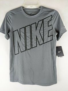 New with Tags Nike Boys Gray Short Sleeve Dri-Fit Athletic Activewear Shirt  Item #827994 Youth Boys Size: Large Color:  Gray with black NIKE logo on front Swish on sleeve Round collar Short Sleeves Dri-Fit Tagless Retail MSRP:  $25 Material:  92% Polyester, 8% Spandex Material care:  Machine wash, cold and Tumble dry, low Approximate measurement of garment, laying flat: Armpit to Armpit:  16-1/2" Length:  23" Sporty Fitted Tops With Logo, Fitted Sporty Tops With Logo, Logo Fitted Crew Neck Top, Fitted Logo Top With Short Sleeves, Fitted Short Sleeve Tops With Logo, Fitted Cotton Tops With Logo, Nike Fitted Sports Shirt, Nike Fitted Shirt For Sports, Fitted Nike Sports Shirt