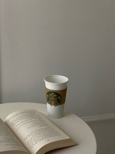 an open book with a starbucks cup on top