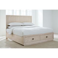 a bed with two drawers underneath it in a white room next to a large window