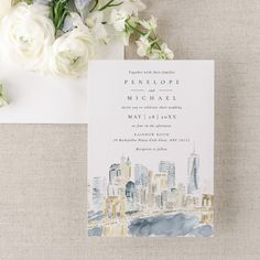 a watercolor cityscape wedding suite with white flowers and greenery