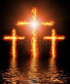 three crosses on fire reflected in water with bright light behind them and dark sky background