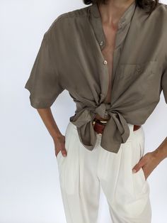 Beautiful latte toned silk top - this blouse has a collarless neckline and iridescent matching buttons down the front & a single breast pocket. Tag reads Personal Choice Faint discolorations at the sleeves and at front with very subtle discolorations under arms. Elegant Beige Tops With Pockets, Casual Silk Blouse With Buttons, Elegant Brown Short Sleeve Blouse, Elegant Solid Color Blouse With Pockets, Elegant Semi-formal Top With Pockets, Silk Tops For Semi-formal Summer Occasions, Classic Collared Neutral Blouse, Chic Neutral Collared Blouse, Chic Khaki Collared Blouse