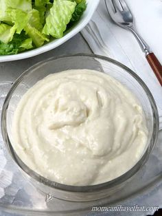 a bowl of dressing next to a salad