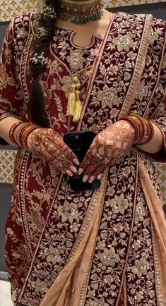 a woman wearing a red and gold outfit with her hands on her chest, holding a black box