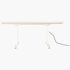 a white table with an electric cord connected to the top and bottom part of it