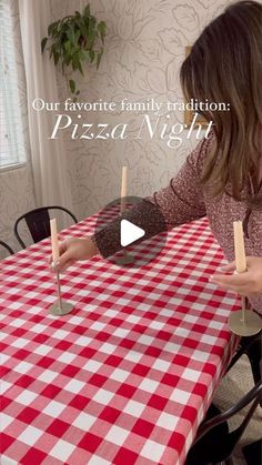 a woman sitting at a red and white checkered table with pizza sticks sticking out of it