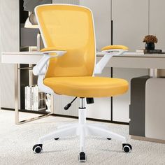 a yellow office chair sitting on top of a white desk next to a book shelf