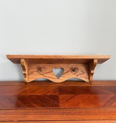 a wooden shelf with two hearts cut out of it