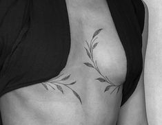 a black and white photo of a woman's breast with leaves on it,