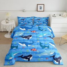 a bed room with a neatly made bed covered in blue comforter and pillows on top of it