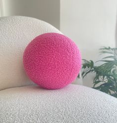 a pink ball sitting on top of a white chair