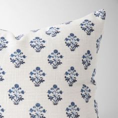 a white pillow with blue flowers on it