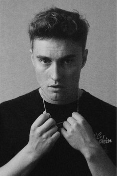 black and white photograph of a young man tying his tie