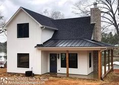 a white house with a black roof and brick chimney