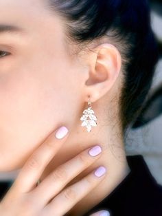 a close up of a person wearing some kind of earring with flowers on it