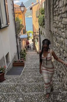 a woman is walking down an alley way