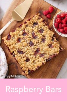 raspberry bars on a cutting board with strawberries