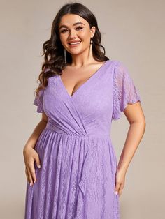 a woman in a purple dress posing for the camera