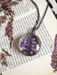 purple flowers in a glass pendant on a book