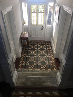 an entry way with a checkered floor and stained glass window