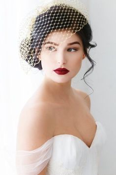 a woman wearing a veil and red lipstick