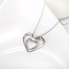 Discover the exquisite charm of our "Infinity Love Heart Sterling Silver Necklace" – a symbol of the timeless bond between two hearts. This necklace beautifully captures the essence of affection with its stunning design. The pendant features a larger silver heart-shaped outline, within which resides a smaller heart shape adorned with clear white cubic zirconias, adding a touch of brilliance and elegance. Overlapping this inner heart is a rose gold infinity symbol, representing the eternal nature Infinity Jewellery, Infinity Necklace With Names, Infinity Symbol Necklace, Infinity Necklace Gold, Infinity Cross, Double Infinity, Infinity Necklace Silver, Necklace Infinity, Simple Silver Jewelry