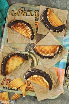 four waffles are sitting on top of each other in brown paper wrappers