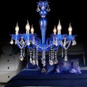 a blue chandelier sitting on top of a bed next to a night stand