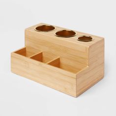 a wooden box with three cups in it