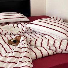 two red and white striped bedspreads on top of each other in a bedroom