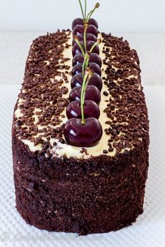 a chocolate cake with white frosting and cherries