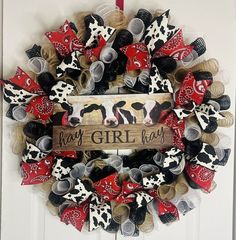 a wreath is decorated with red, white and black bows that say hey girl on it