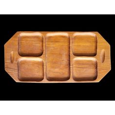 a wooden tray with four compartments on it