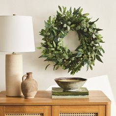 a table with a lamp and a wreath on it