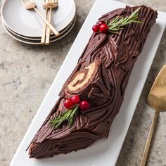 a piece of chocolate cake sitting on top of a white plate next to silverware