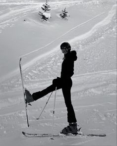 a person riding skis on top of a snow covered slope with trees in the background