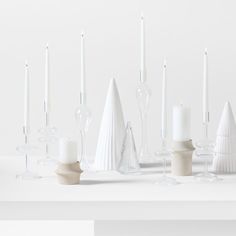 white candles are lined up on a table