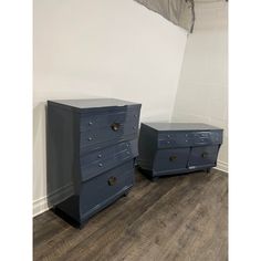 two blue dressers sitting next to each other on top of a hard wood floor