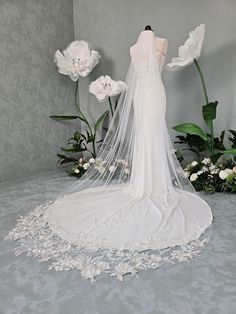 a white wedding dress on display in front of flowers