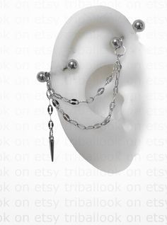 a pair of balls and chains are attached to a fake ear with an acrylic ball