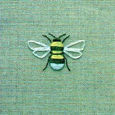 a close up of a bee on a green cloth with yellow and black stripes in the center