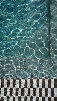 an empty swimming pool with clear water and checkerboard pattern on the bottom floor