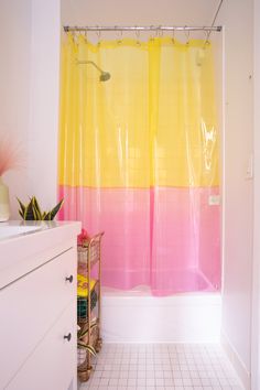 a bathroom with a yellow and pink shower curtain