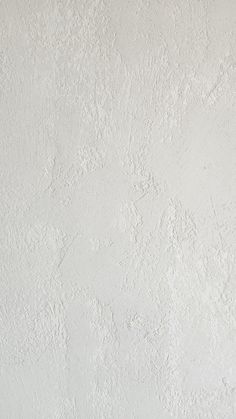 a black and white cat sitting on top of a window sill next to a wall