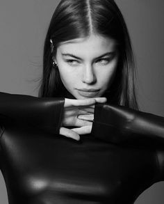 black and white photograph of a woman in leather clothing with her hands on her chest