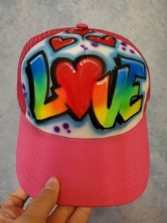 Classic airbrush name on a trucker cap.  Can also use a different background or colors, please use notes section to describe your design.  Choose style and colors - Primary Rainbow, 2 Color Mix, Beach Scene or Flames.  Custom graphics or logos on airbrushed on trucker style hats - these are ideal gifts and can be purchased in bulk for party favors at a special price.  These upgraded airbrush hats feature the incredible artwork of our talented artist Fester,  the attention to detail is unmatched! Multicolor Curved Brim Hat With Letter Print, Multicolor Snapback Hat With Letter Print, Pink Fun Snapback Hat With Flat Bill, Fun Pink Snapback Hat With Flat Bill, Pink Fun Flat Bill Snapback Hat, Multicolor Baseball Cap With Letter Print, Multicolor Snapback Hip Hop Hats, Multicolor Hip Hop Snapback Hat, Hip Hop Multicolor Snapback Hat