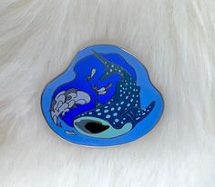 a blue and white brooch with an animal on it