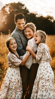 a family hugging each other in the middle of a field